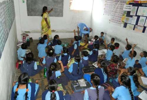 Children and their teacher in a classroom displaying pupils’ work
