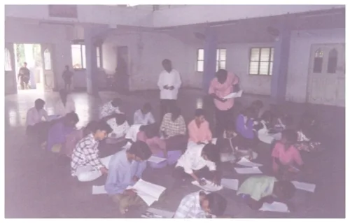 Young participants writing during a competition organised by the Mandal
